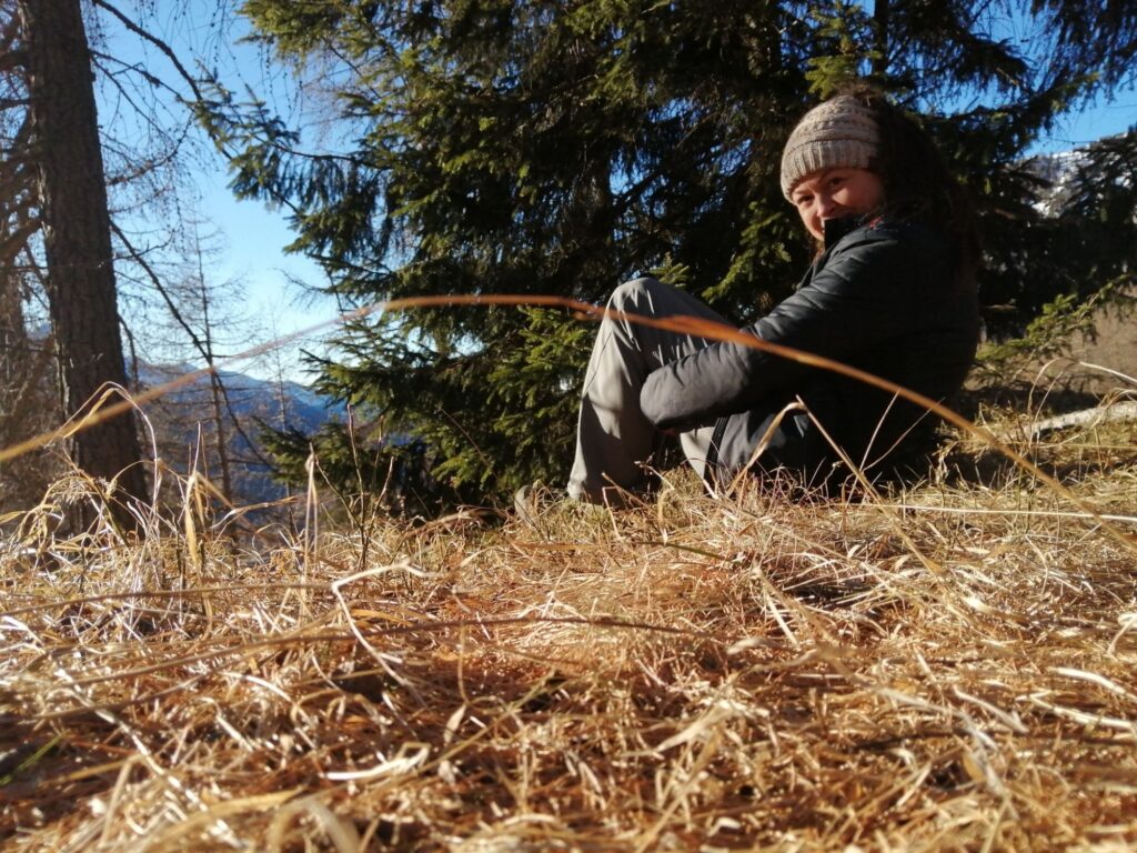 Luisa Capellino seduta in una radura nel bosco - immagine per l'articolo perché artigiana forestale